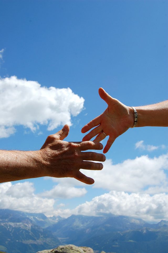 2 hands almost shaking with blue sky background